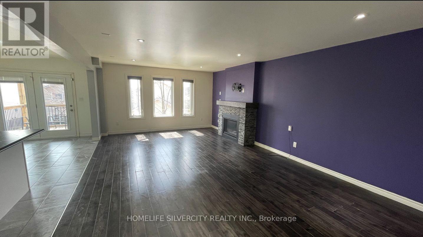 A spacious room with purple walls and wooden flooring.