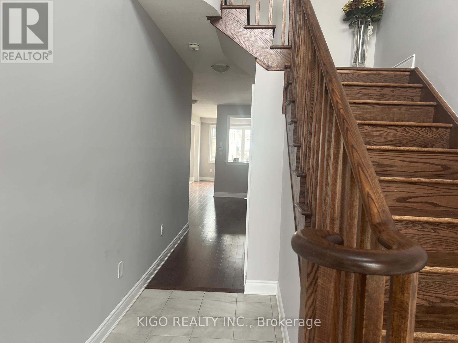 A wooden staircase with a metal railing leads to a second floor.