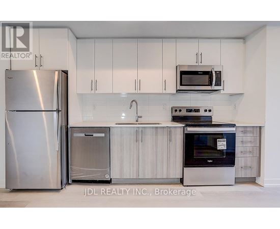A kitchen with white cabinets and stainless steel appliances.
