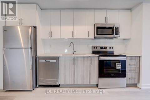 A kitchen with white cabinets and stainless steel appliances.