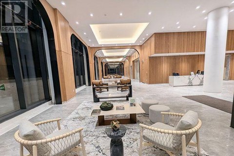 A spacious living room with a long hallway, furnished with a sofa, armchairs, and a coffee table.