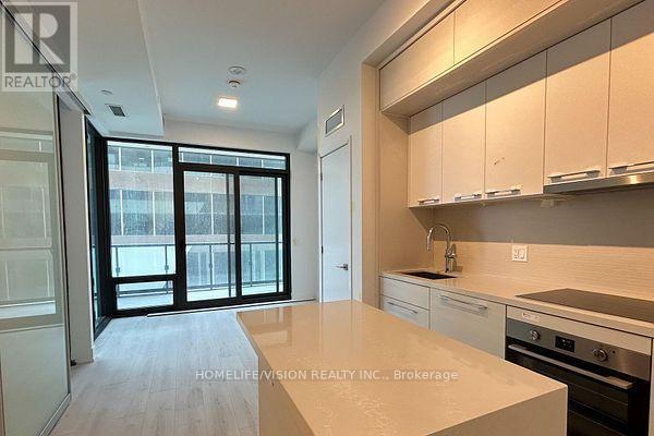 A kitchen with white cabinets and a marble countertop.