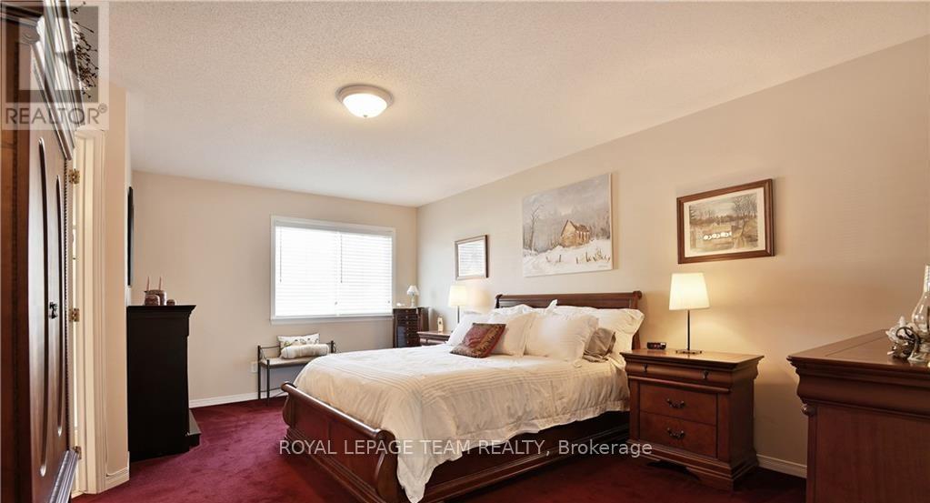 A bedroom with a large bed, a nightstand, and a dresser.