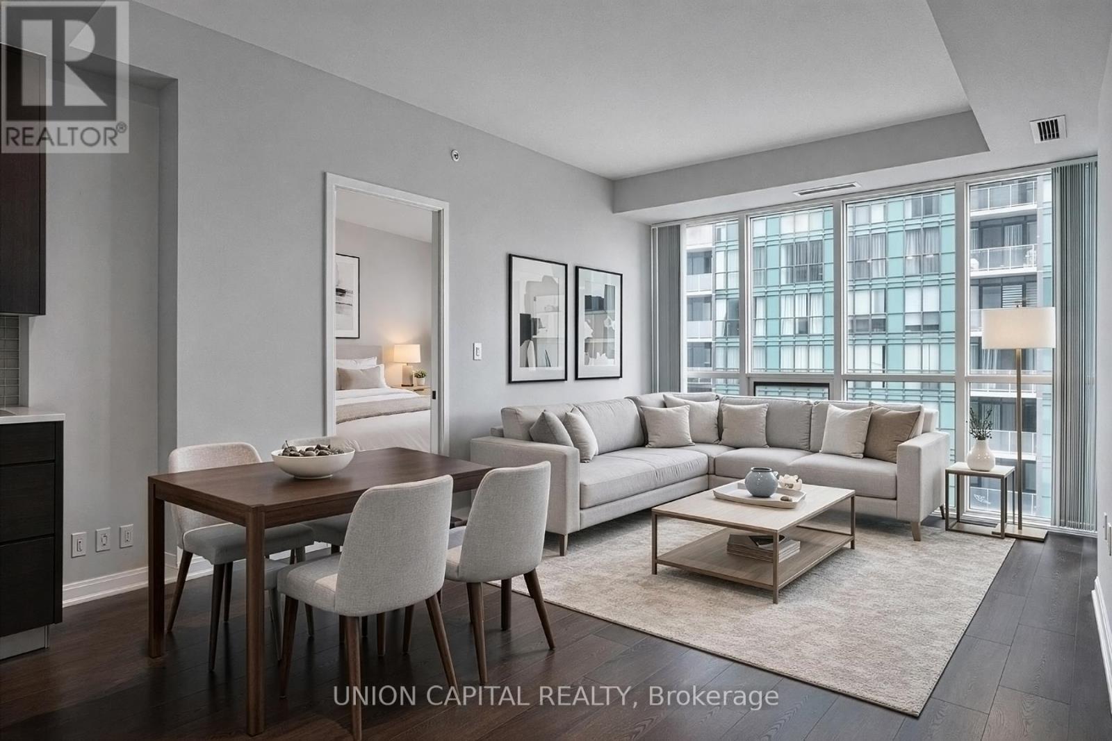 A modern living room with a dining table and chairs.