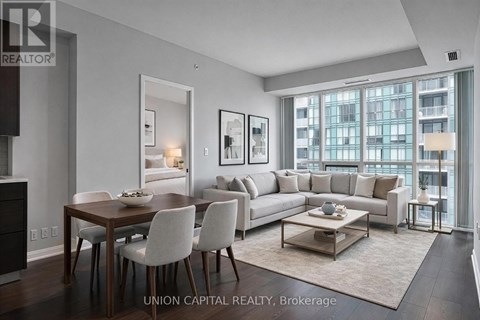 A modern living room with a dining table and chairs.