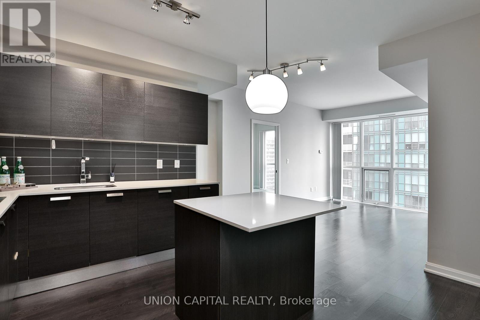 A modern kitchen with black cabinets and a large island.