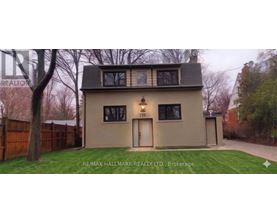 A house with a brown fence and a green lawn in front.