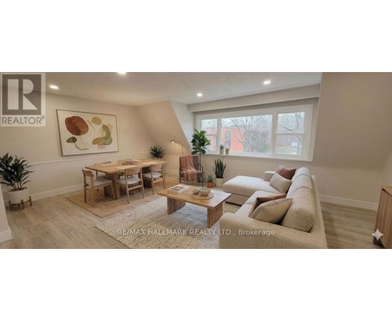 A living room with a couch, a table, and a painting on the wall.