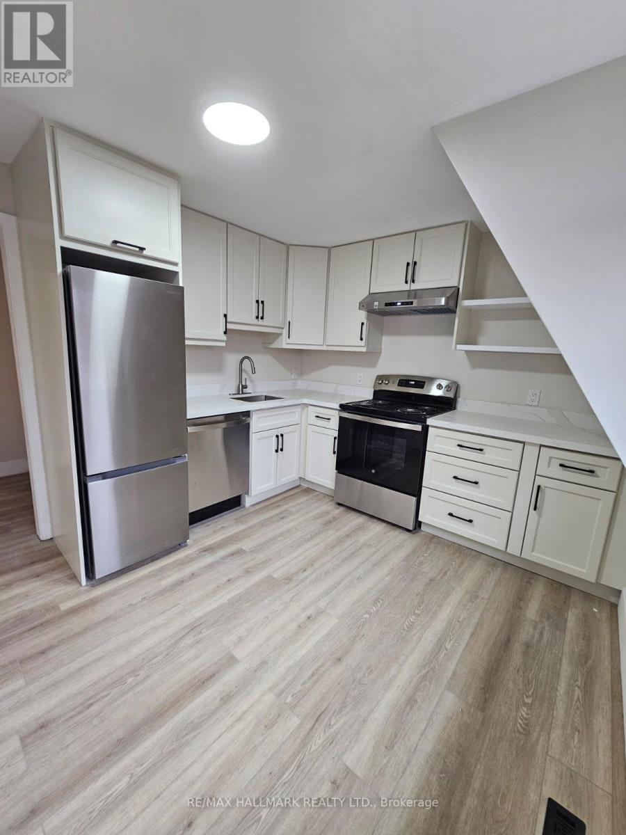 A kitchen with white cabinets and a stainless steel refrigerator.