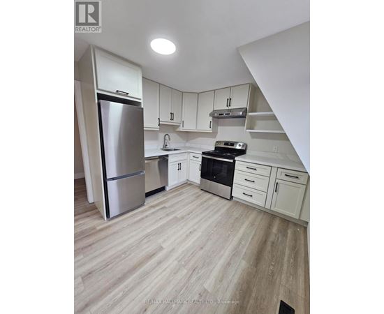 A kitchen with white cabinets and a stainless steel refrigerator.