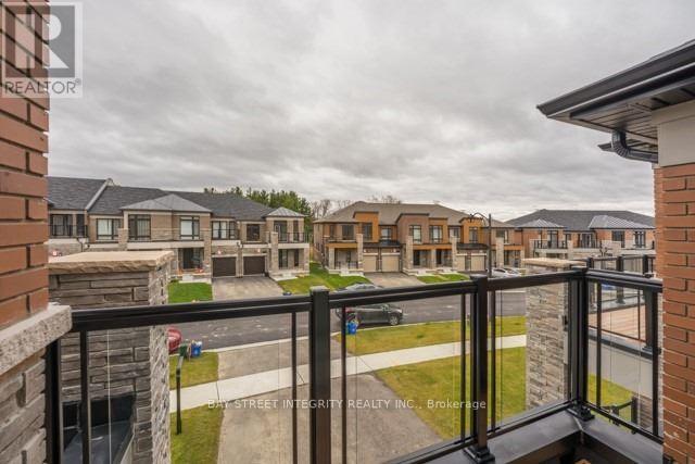 A balcony overlooks a grassy area and apartment buildings.
