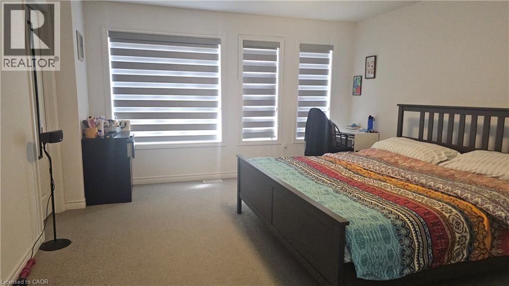 A bedroom with a bed, dresser, and window with blinds.
