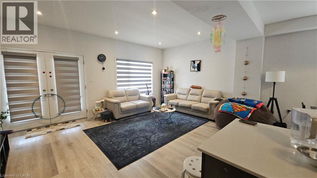 A living room with a white couch and a black rug.