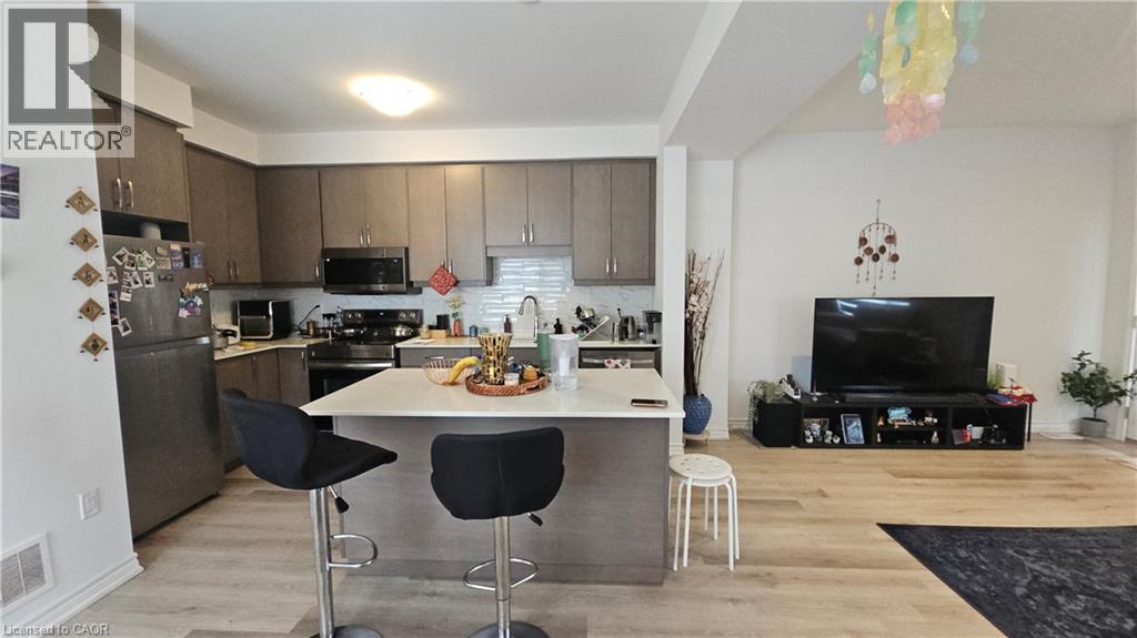 A kitchen with a table and chairs in front of a refrigerator.