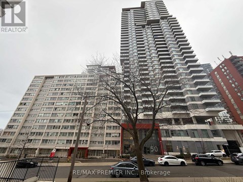 A tall building with a red and white sign in front of it.