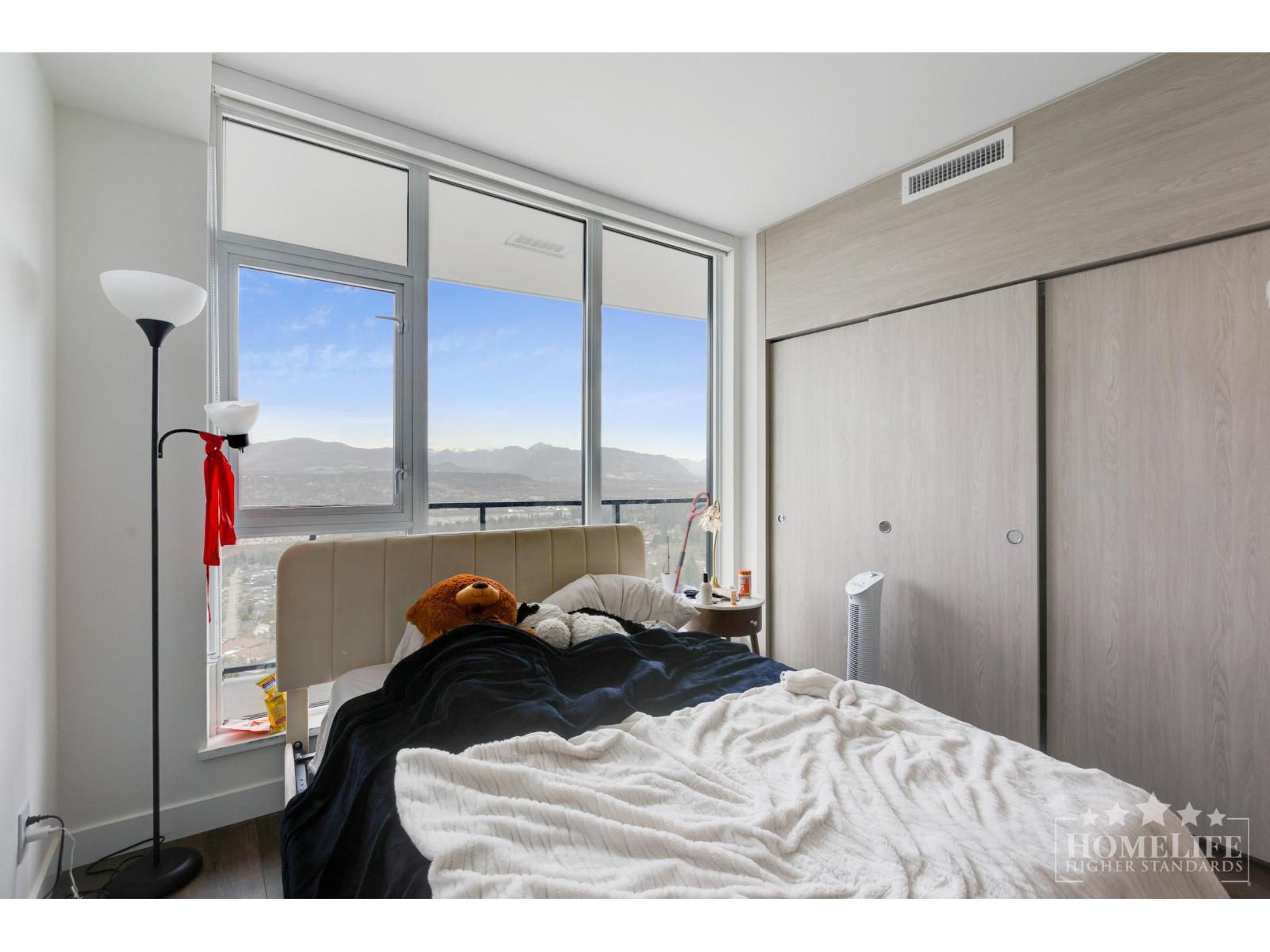 A bedroom with a large bed and a window overlooking the mountains.