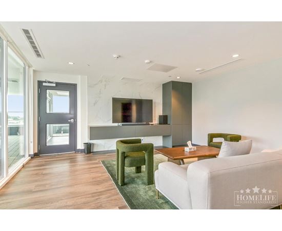 A modern living room with a white sofa, green armchair, and a wooden coffee table.