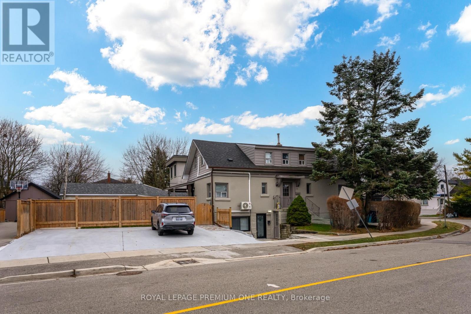 A house with a fence and a car parked in front.