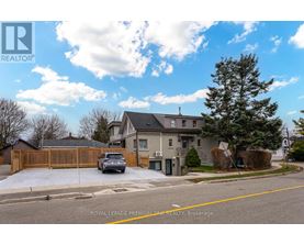 A house with a fence and a car parked in front.