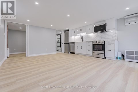 A spacious kitchen with white cabinets and appliances.
