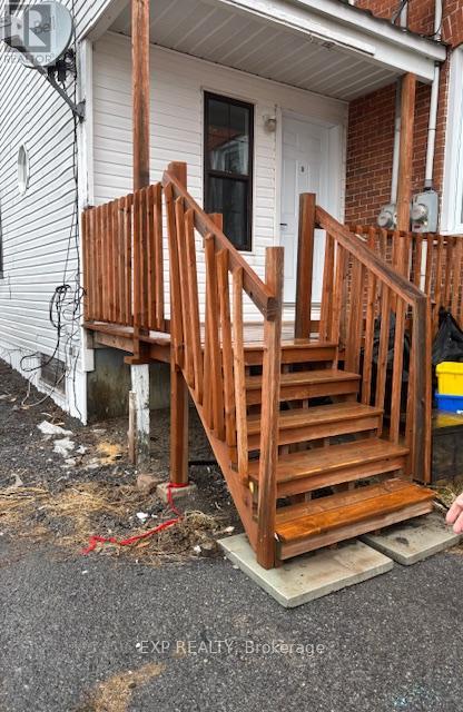 A wooden staircase is being installed outside a house.