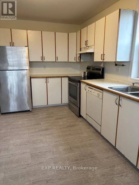 A kitchen with white cabinets and a stainless steel refrigerator.