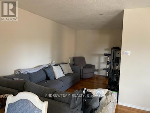 A living room with a grey couch and a white chair.