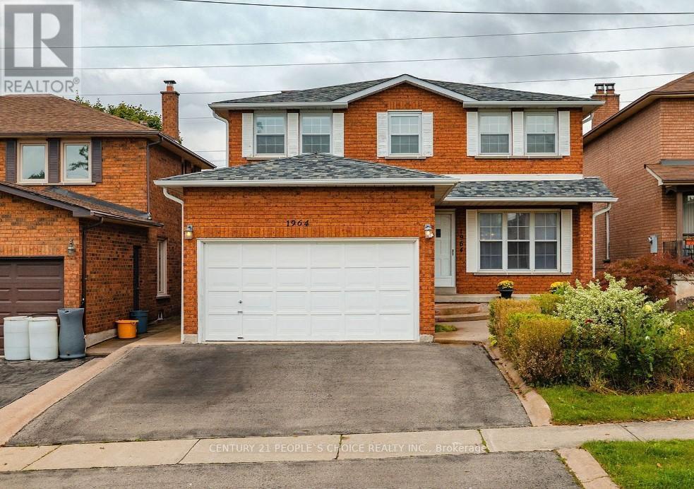 A red brick house with a white garage door in front.