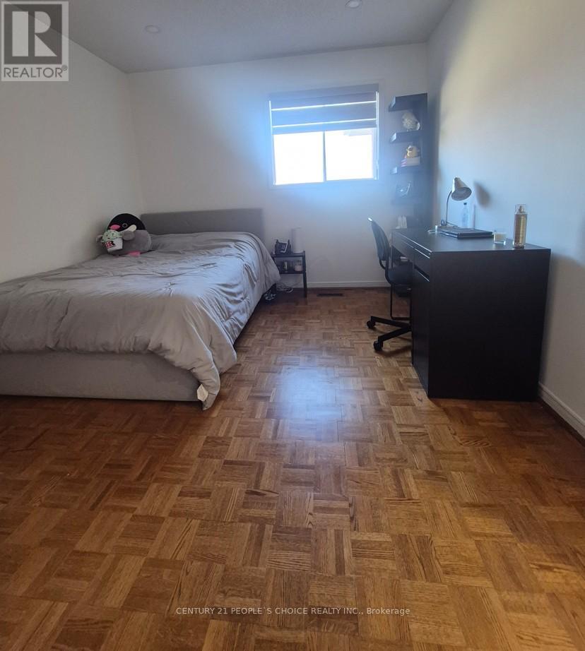 A bedroom with a bed, desk, and chair.