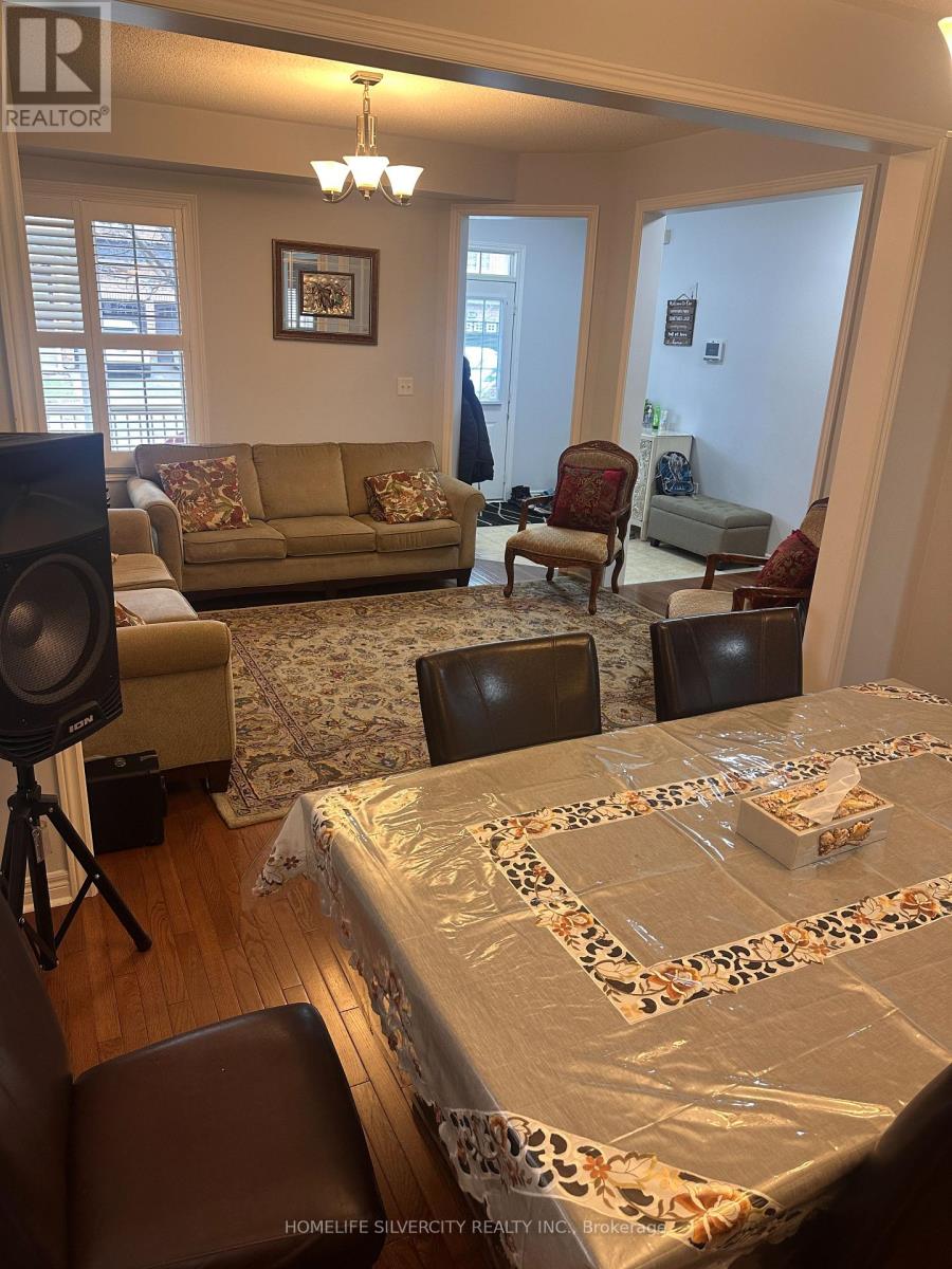 A living room with a couch, chairs, and a dining table set up with a tablecloth.