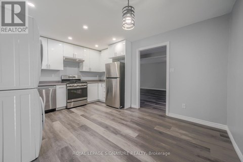 A kitchen with white cabinets and a refrigerator.