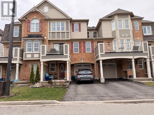 A large, multi-story residential building with a car parked in the driveway.