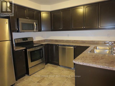 A kitchen with brown cabinets and stainless steel appliances.