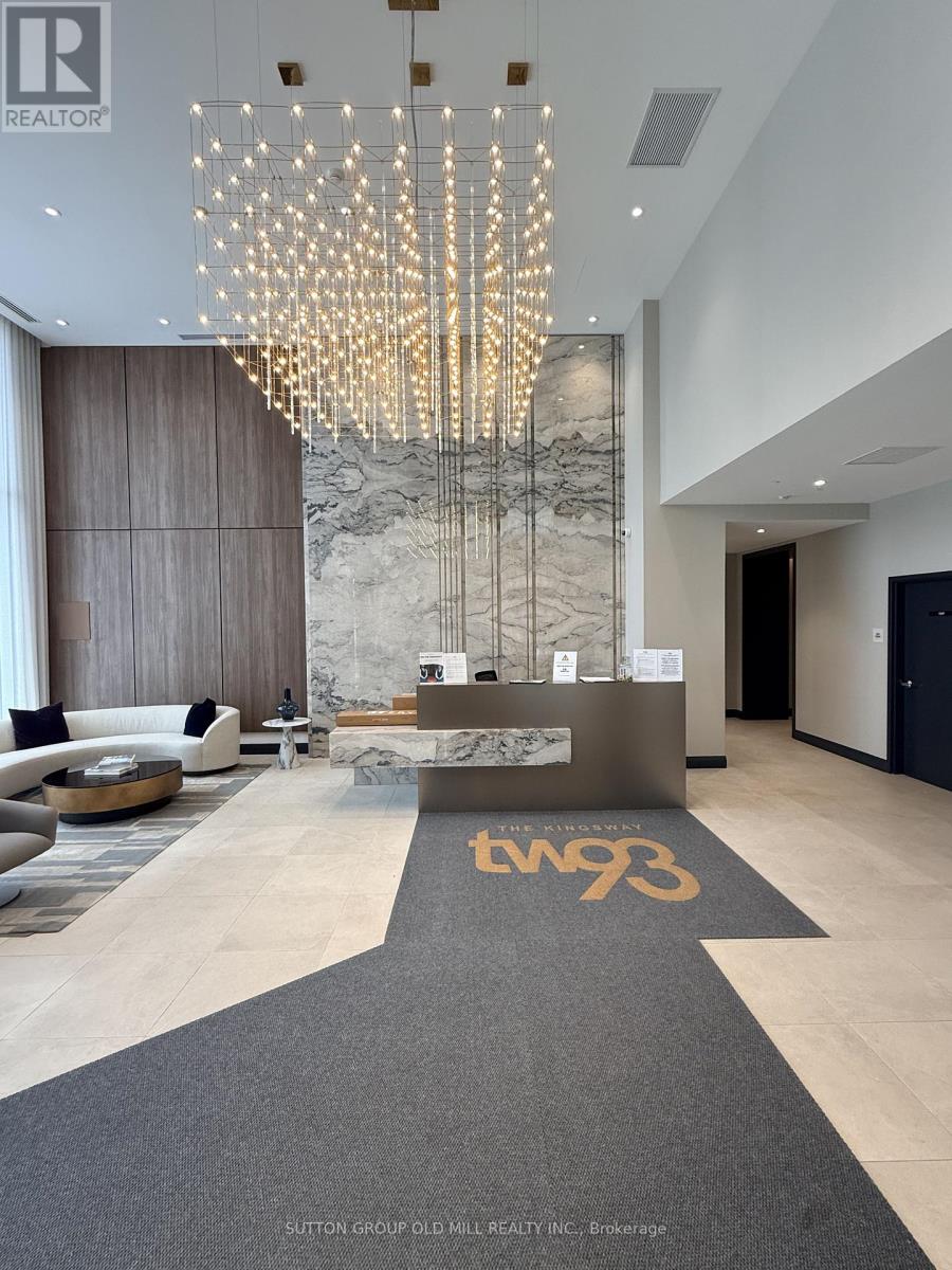 A reception area with a large chandelier and a reception desk with the number 793 on it.