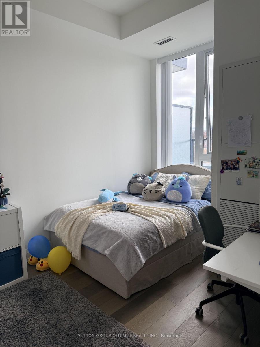 A bedroom with a bed, a chair, a desk, and a window.