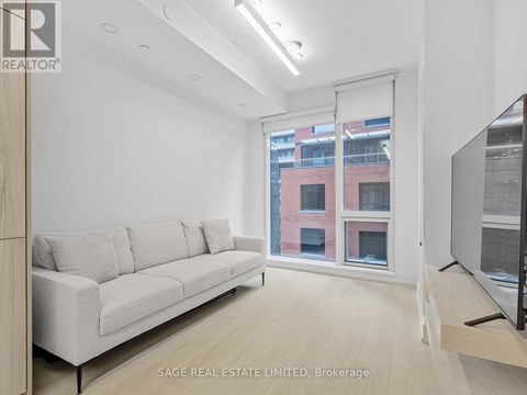 A living room with a white couch and a flat screen TV.