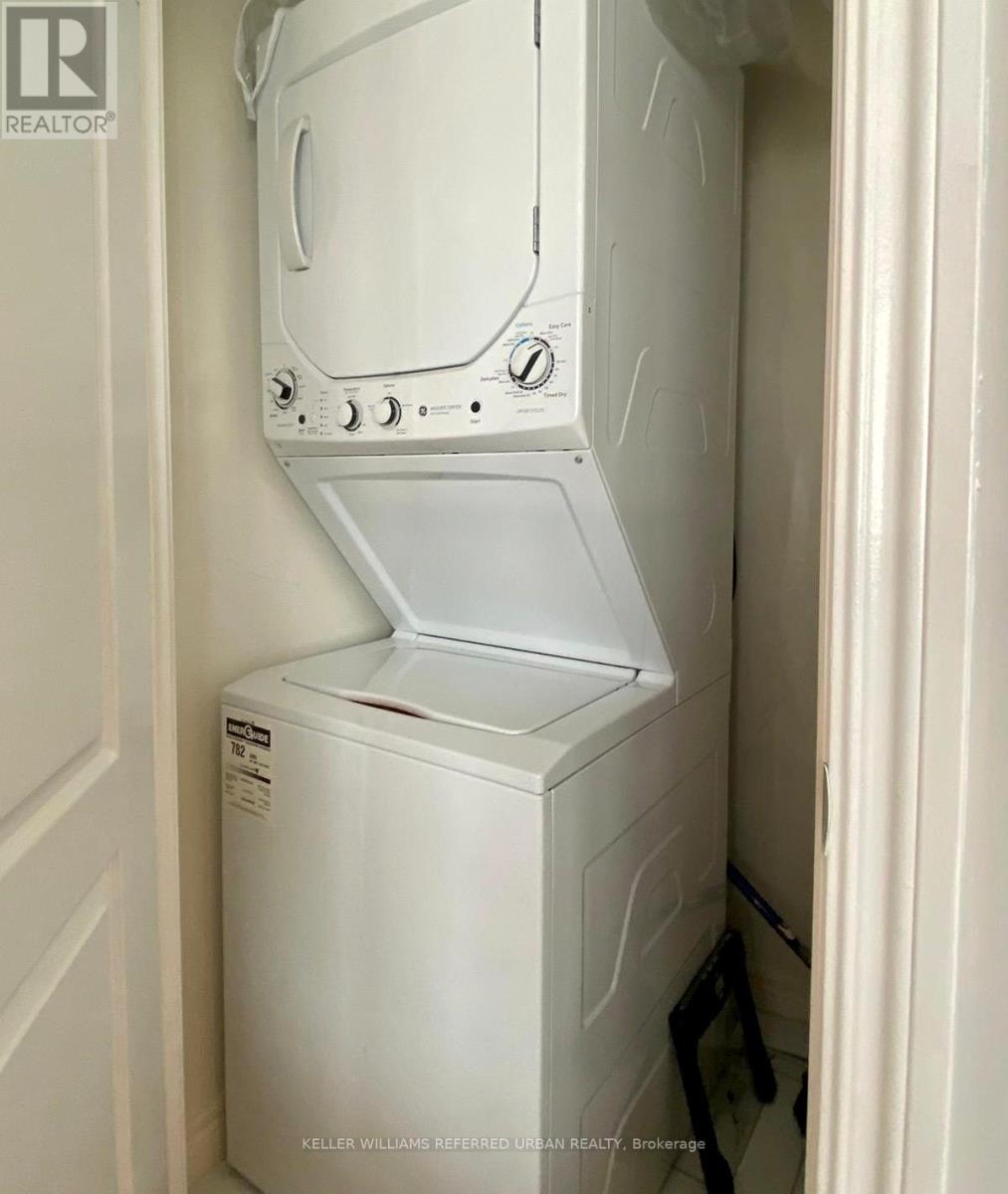 A white dryer is in a small space.