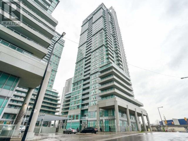 A tall building with many windows stands next to a shorter building with balconies.