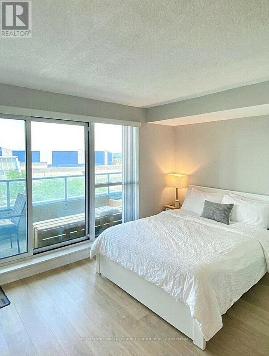 A bedroom with a large bed and a view of the outside.