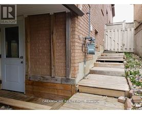 A house with a white door and wooden steps leading to it.