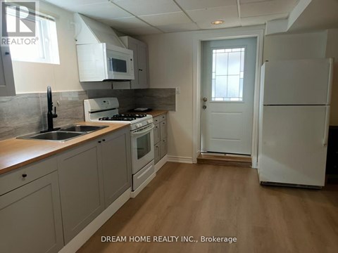 A kitchen with a white refrigerator and a white door.
