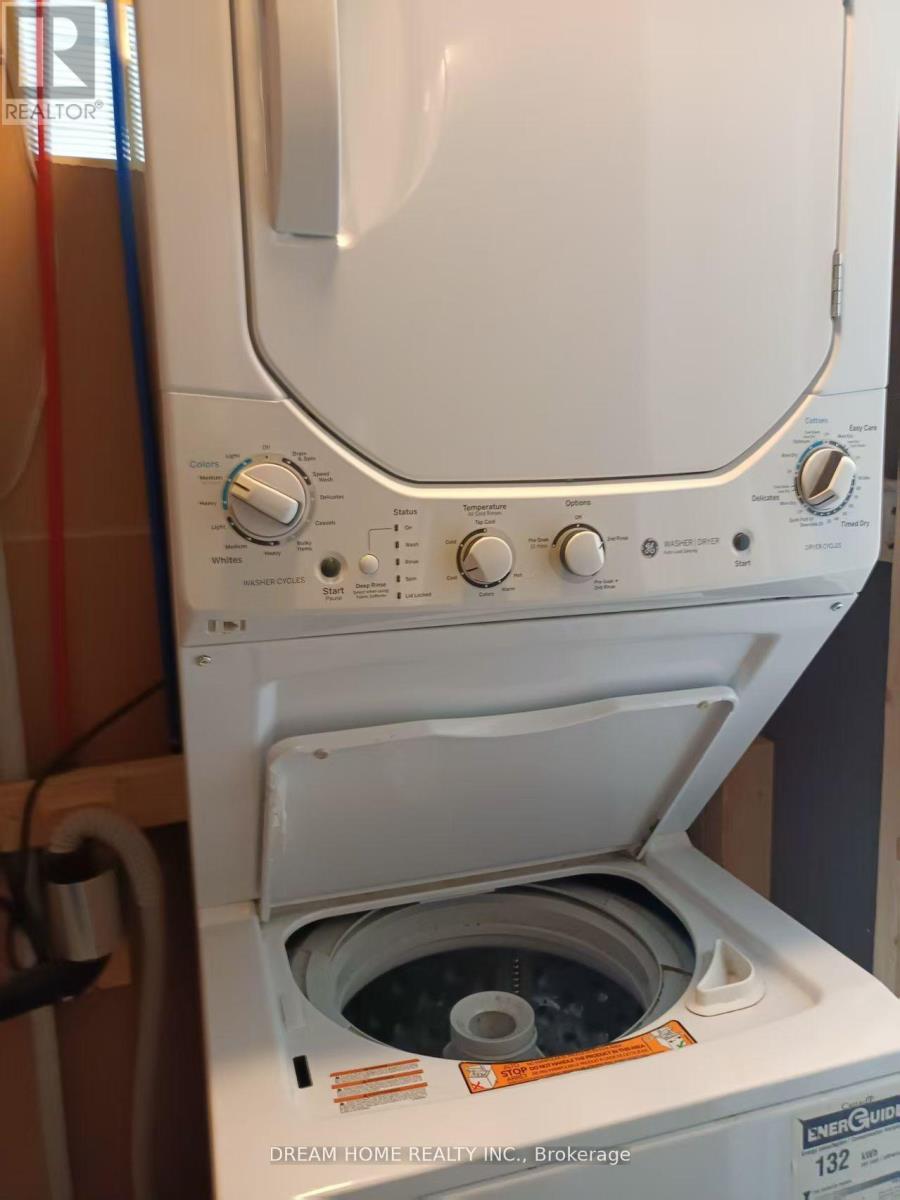 A white dryer with the door open is in front of a wall.
