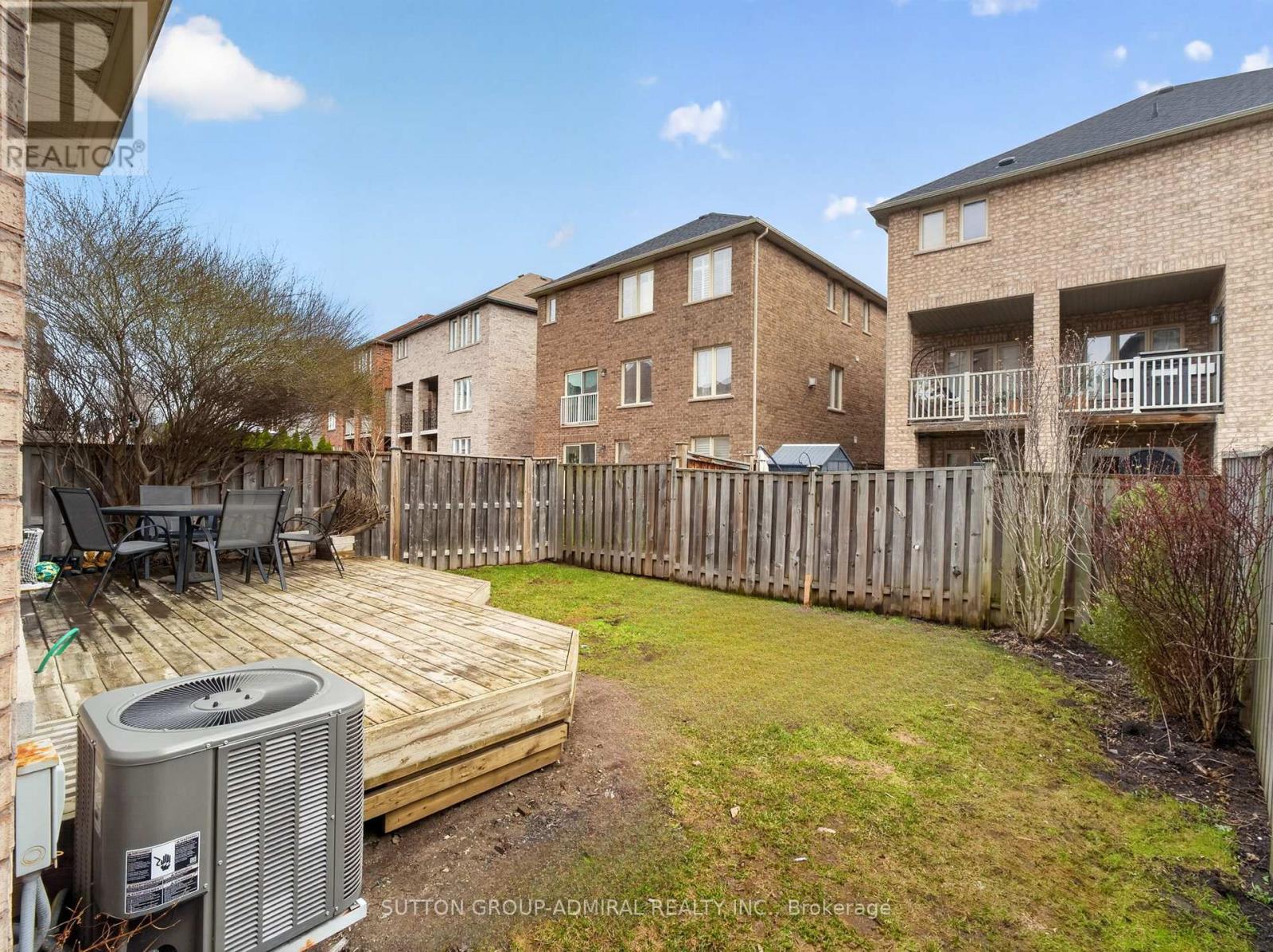 A backyard with a deck and a hot tub.
