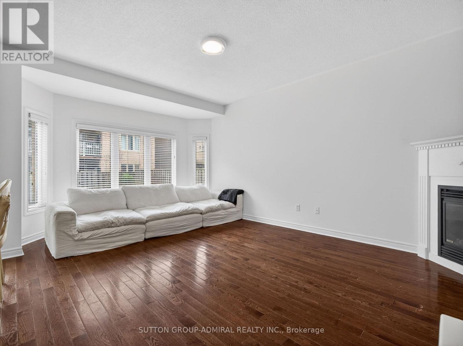 A living room with a white couch and wooden floors.