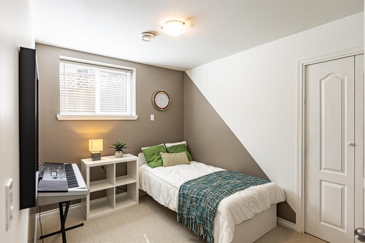 A bedroom with a bed, nightstand, and window.