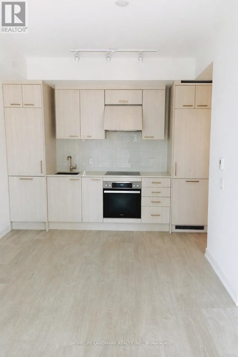 A kitchen with white cabinets and a black oven.