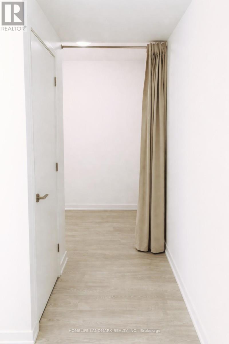 A hallway with a beige curtain and a white door.