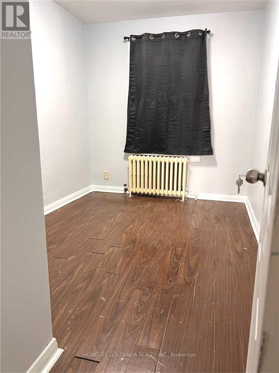 A room with a wood floor and a radiator.