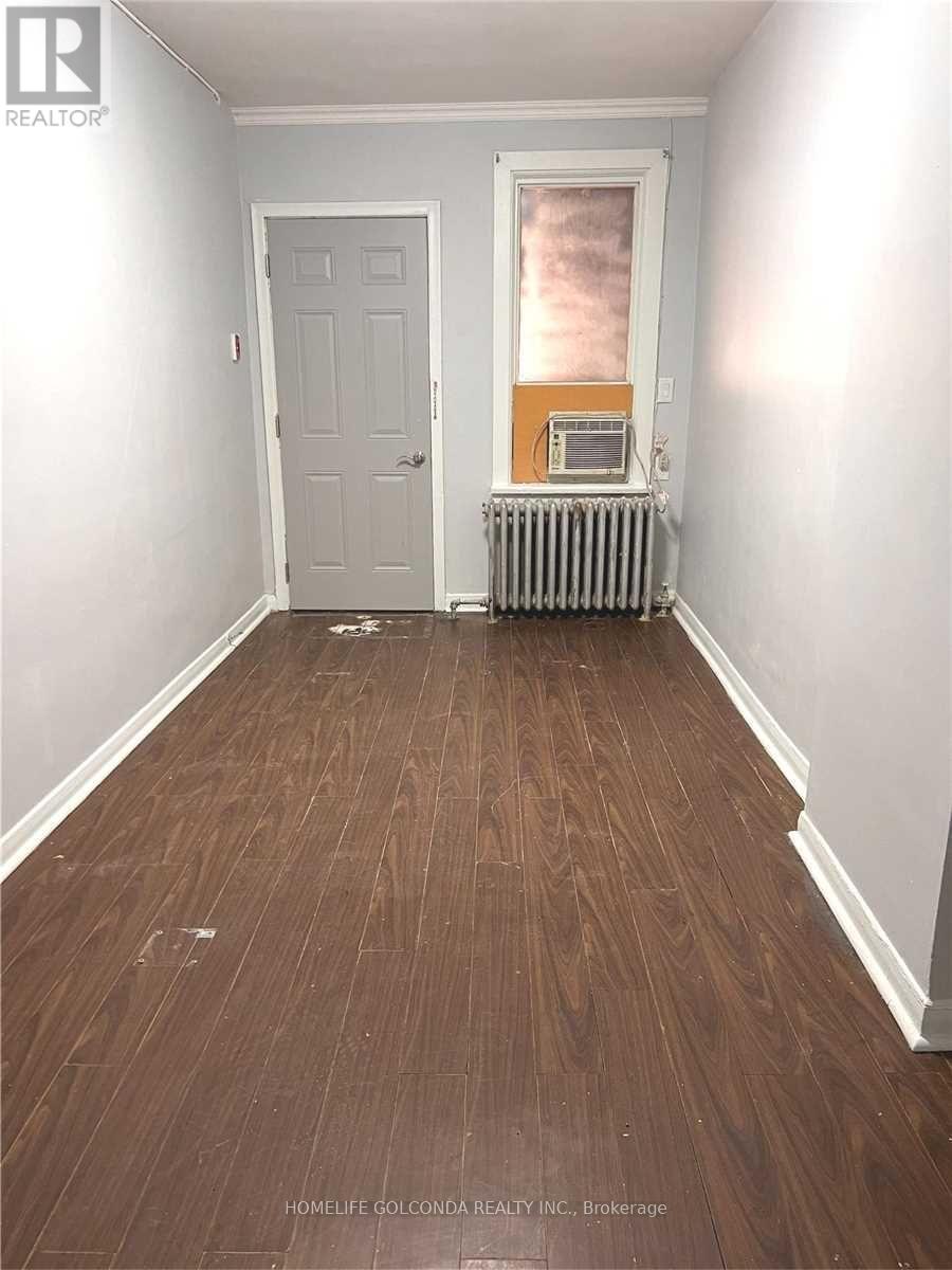 A room with a wooden floor and a white door.