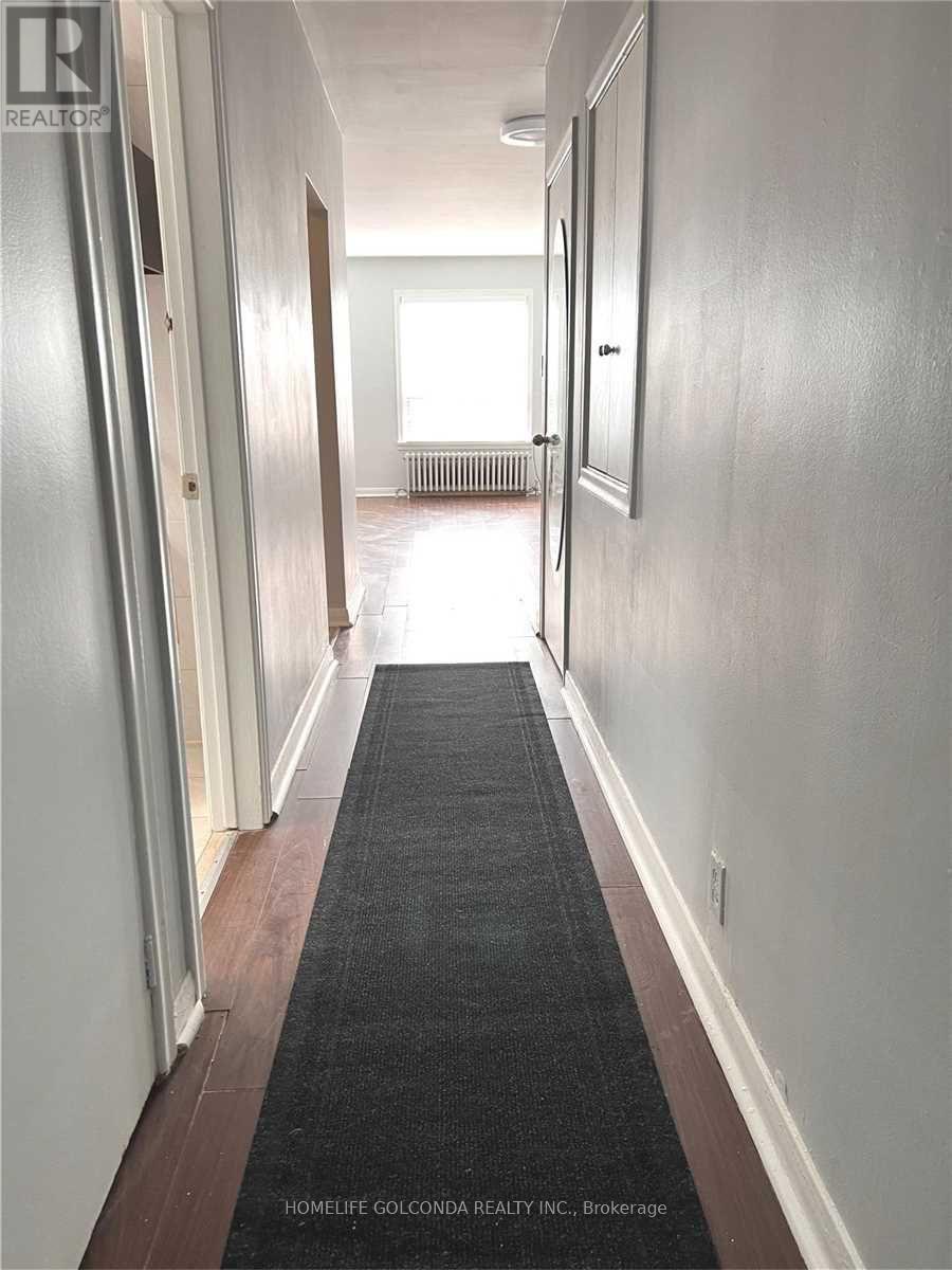 A hallway with a black carpet and white walls.